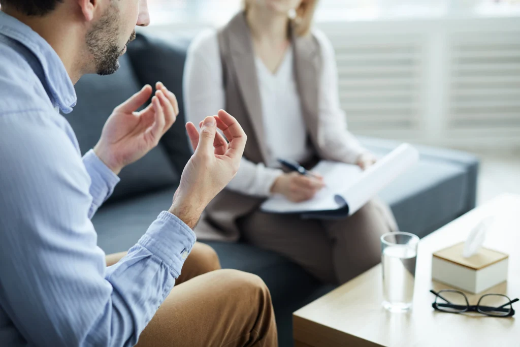 Therapy for military families: a man talks with his hands while his therapist takes notes