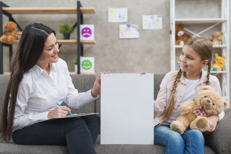 Child psychologist with a girl holding a teddy bear on a sofa